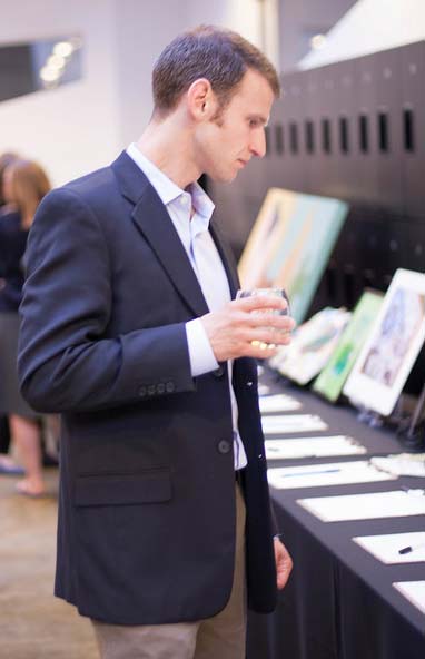 Man looking at art work in silent auction
